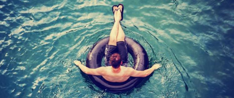 Photo of a man floating on an inner tube.