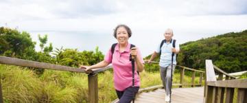 Photo of a senior couple walking up a gently sloped path.