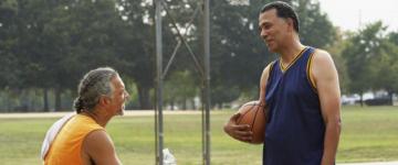 Photo of two men who have paused a 1-on-1 basketball game to talk